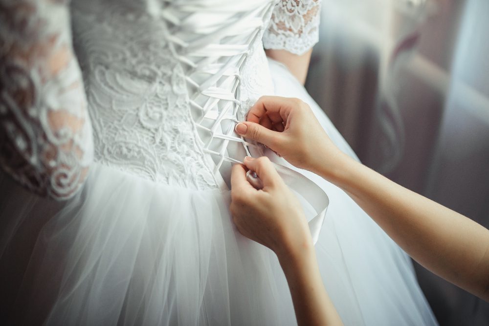 Bridesmaid makes bow-knot on the back of brides wedding dress<br />
